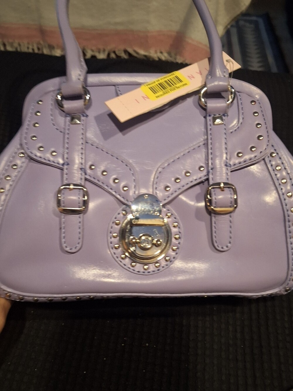 The Gianni Bini Women's Studded Handbag in Lavender is a stylish shoulder bag.
